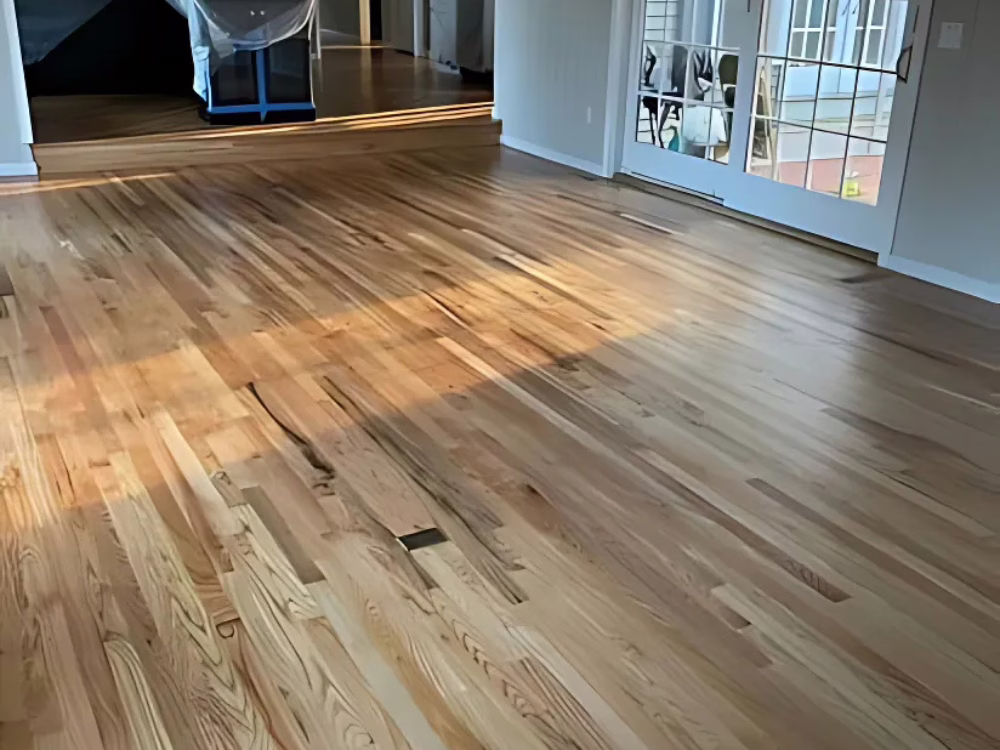 Living room after hardwood floor refinishing in Brookfield CT, showcasing a smooth and natural wood finish.