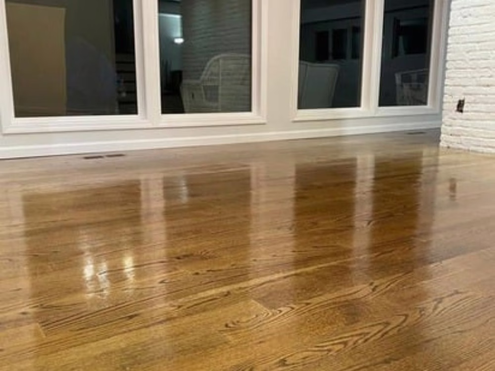 Flooring services showcasing clean hardwood floors with a white brick feature wall and natural light