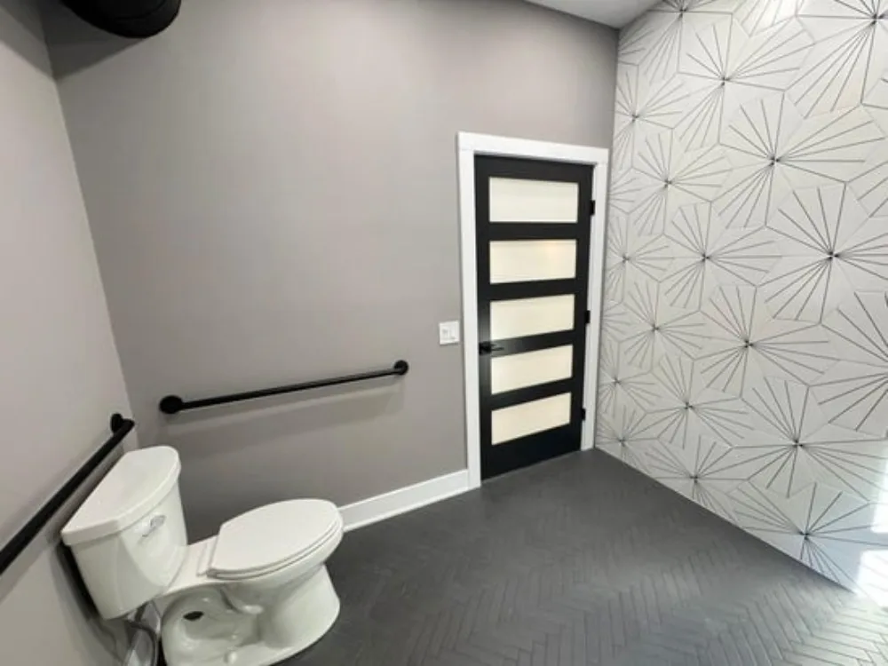 Modern bathroom renovation with sleek fixtures and textured wall design.