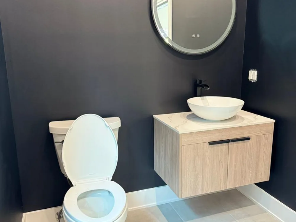 Modern bathroom design with floating vanity, contemporary toilet, and dark walls for a sleek, minimalist look.