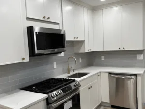 modern kitchen renovation with white cabinets and brass accents